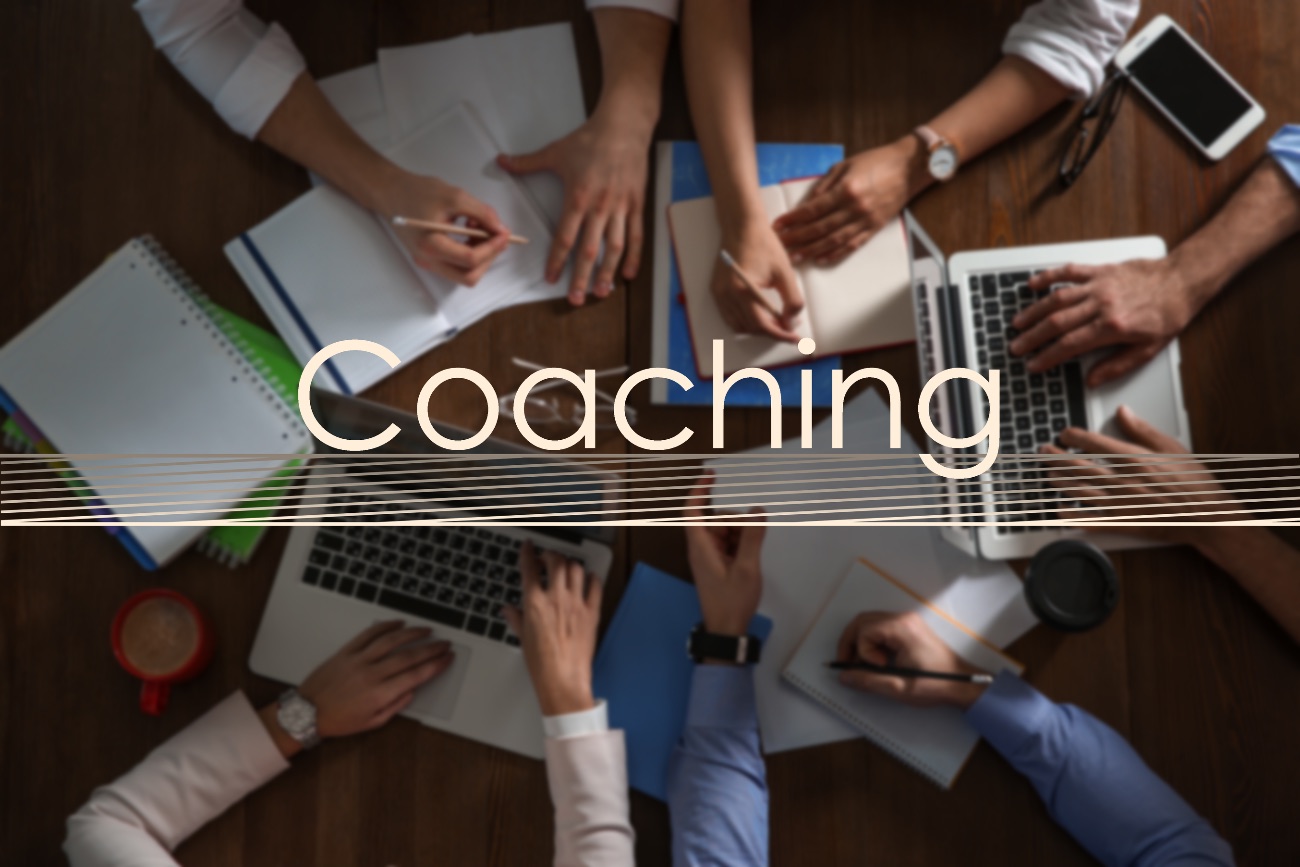Het woord Coaching boven samenwerkende handen